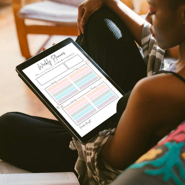 Woman using a digital weekly planner on iPad while relaxing on couch — Paperless Essentials