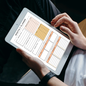 Monthly Digital Planner on an Ipad with 2 hands holding the iPad