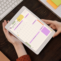 Undated digital monthly work planner PDF template shown on an iPad with a bold modern design in purple, olive green, mustard yellow and orange accents, featuring a top 3 work priorities section, monthly calendar grid, goals section, meetings tracker, to do list, and notes section — compatible with GoodNotes, Notability, Noteshelf, XODO, Samsung Notes, and Kindle Scribe.